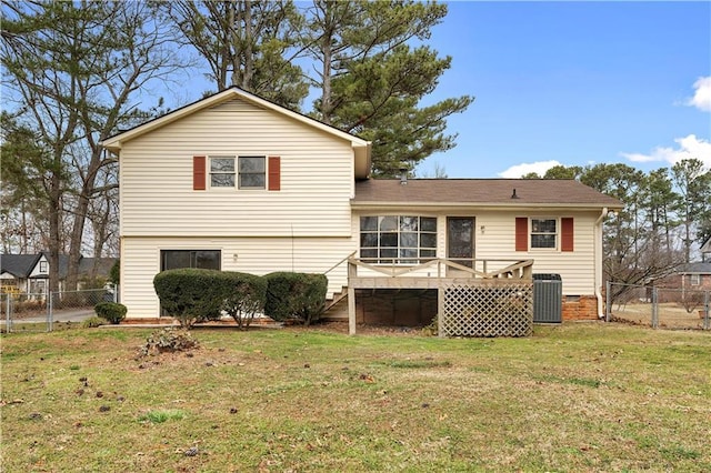 back of property with a yard, fence, a wooden deck, and central air condition unit