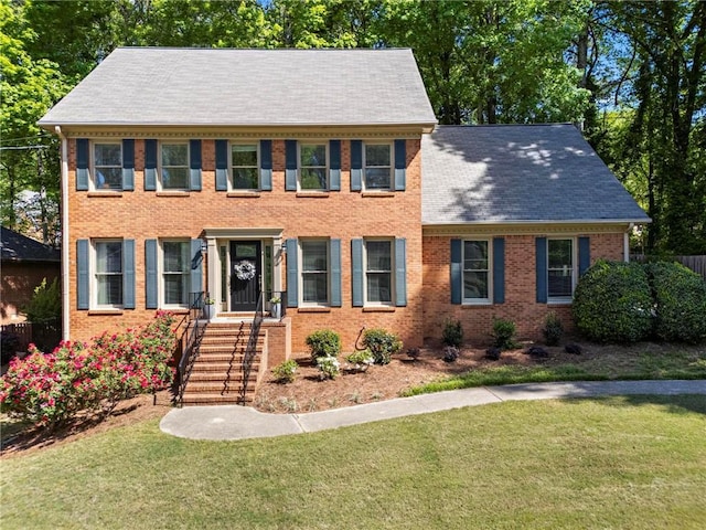 colonial-style house with a front lawn and brick siding