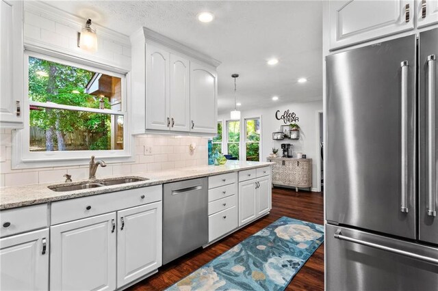 kitchen featuring decorative backsplash, a sink, appliances with stainless steel finishes, and dark wood finished floors