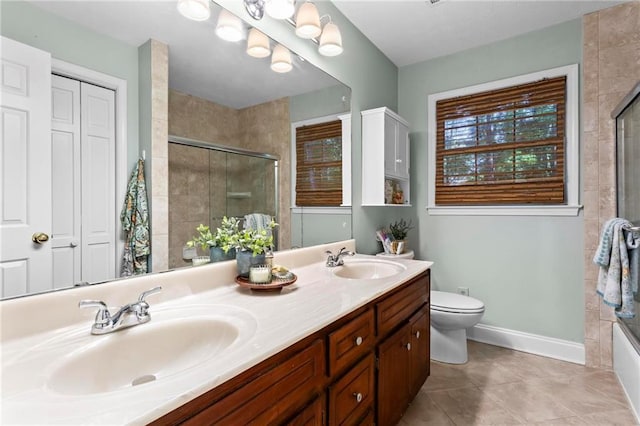 bathroom with tile patterned flooring, a sink, double vanity, and tiled shower