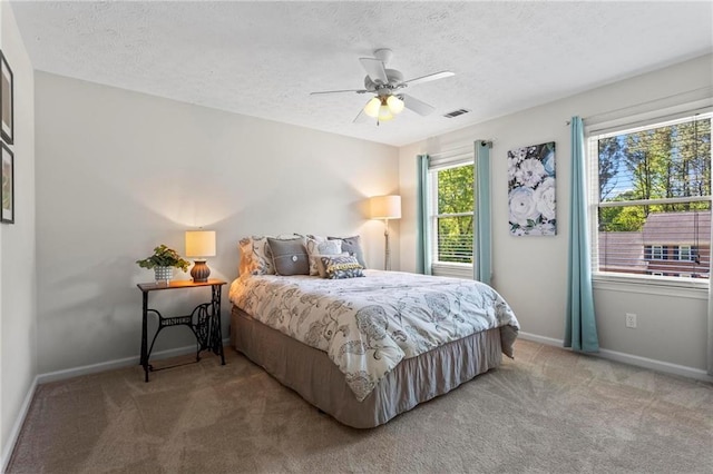 bedroom featuring visible vents, baseboards, carpet flooring, and a textured ceiling