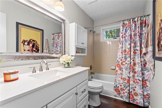 full bathroom with wood finished floors, toilet, vanity, a textured ceiling, and shower / bath combo