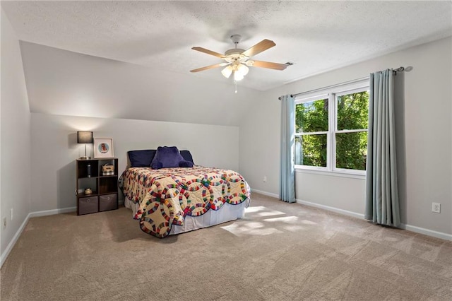 carpeted bedroom featuring vaulted ceiling, a textured ceiling, baseboards, and ceiling fan