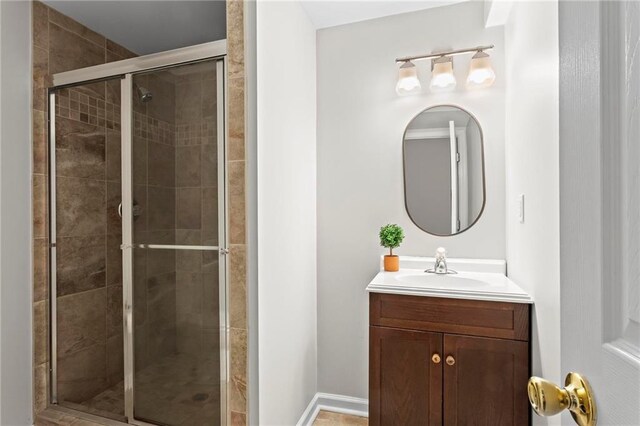 bathroom with a shower stall and vanity