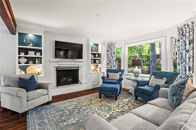 living area featuring a fireplace, wood finished floors, built in shelves, and ornamental molding