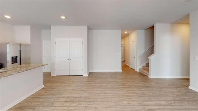 unfurnished living room with a fireplace and light wood-type flooring