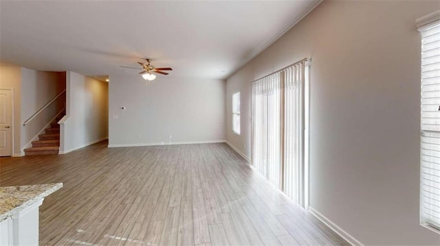 unfurnished room featuring light hardwood / wood-style flooring, ceiling fan, and a wealth of natural light