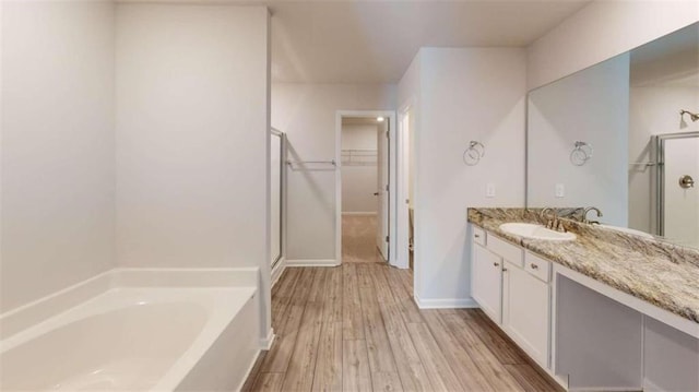 bathroom with independent shower and bath, wood-type flooring, and oversized vanity