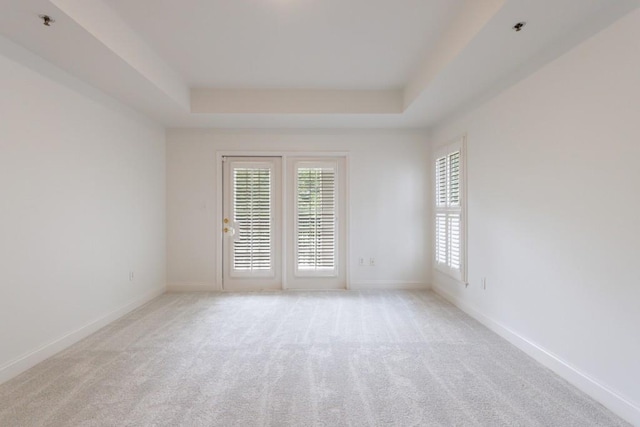 50 Biscayne Dr Unit 2106, Atlanta, GA 30309 - spare room featuring a tray ceiling, light colored carpet, and baseboards