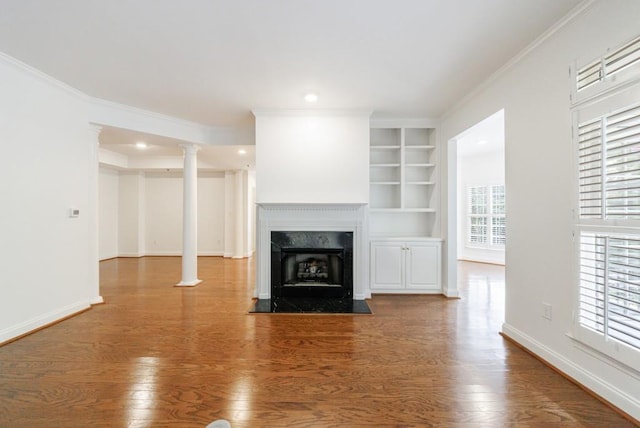 50 Biscayne Dr Unit 2106, Atlanta, GA 30309 - unfurnished living room featuring wood finished floors, built in shelves, baseboards, ornamental molding, and a high end fireplace