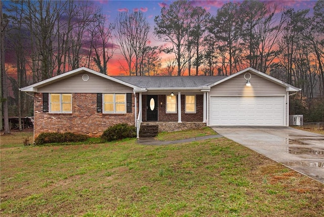 ranch-style house with a garage and a yard