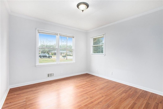 spare room featuring crown molding and light hardwood / wood-style flooring