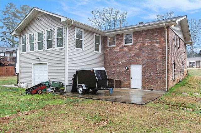 back of property with a garage, a patio area, and a lawn
