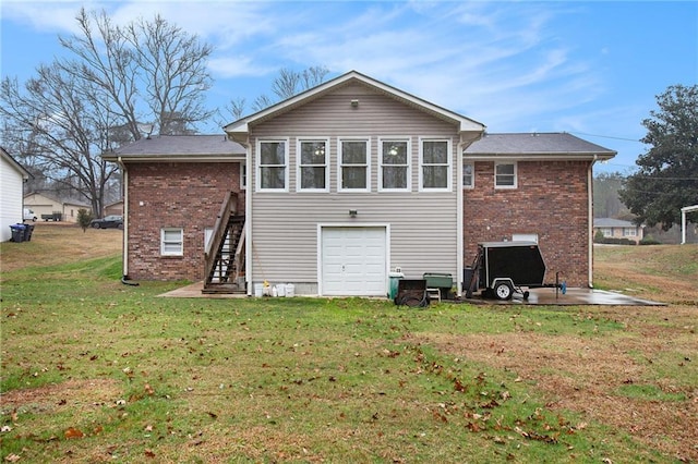 back of house featuring a garage and a yard