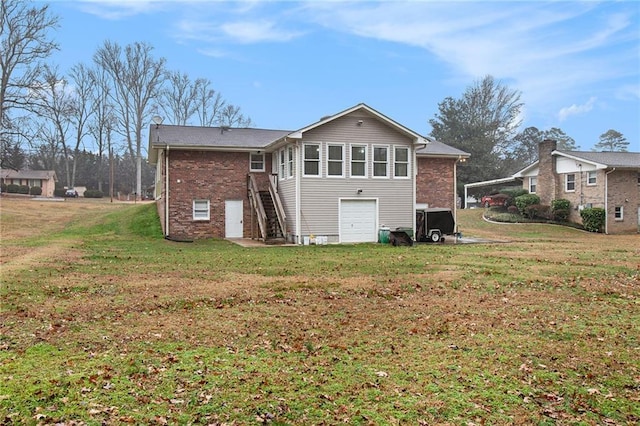 rear view of property featuring a garage and a yard