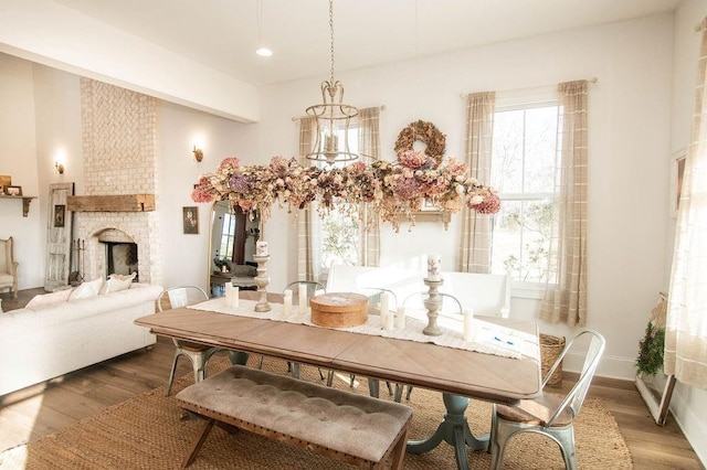 dining space featuring recessed lighting, baseboards, a brick fireplace, and wood finished floors