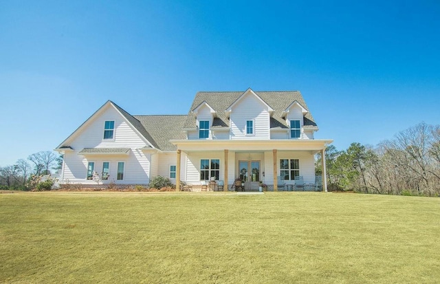 view of front of home with a front yard, a porch, and french doors