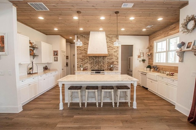 kitchen with visible vents, open shelves, wall chimney exhaust hood, white cabinets, and dishwasher