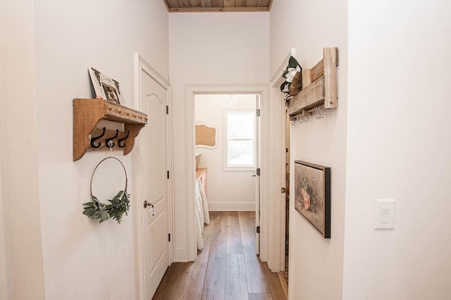 corridor with light wood-type flooring and baseboards