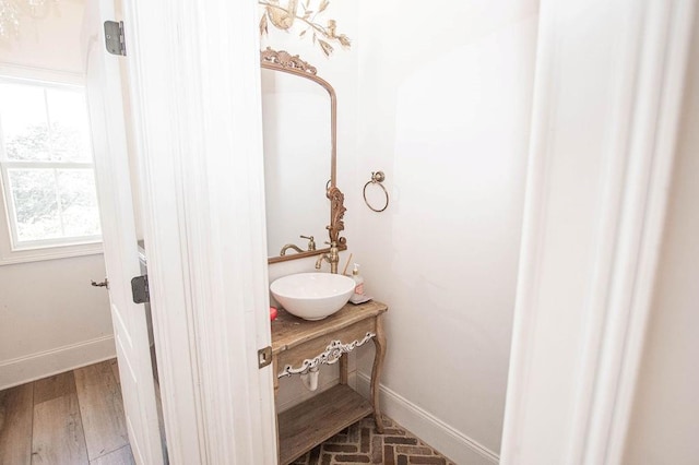 bathroom with wood finished floors, baseboards, and a sink