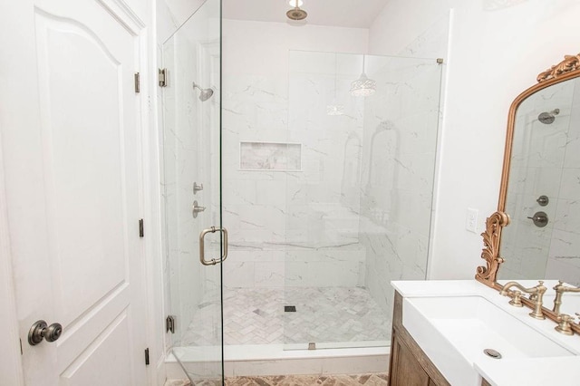 full bathroom with a marble finish shower and vanity