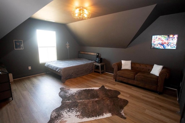 bedroom with lofted ceiling and wood finished floors