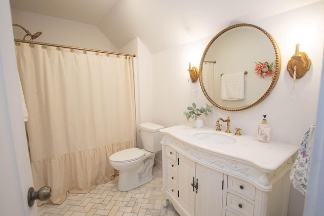 bathroom featuring toilet, vanity, and lofted ceiling