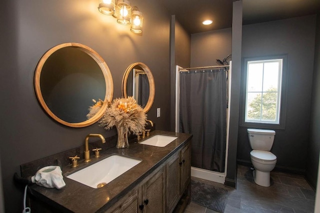 bathroom featuring toilet, baseboards, and a sink