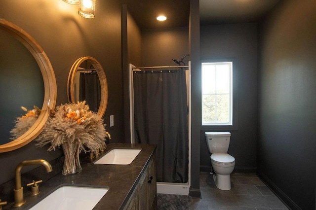 bathroom featuring curtained shower, toilet, baseboards, and a sink