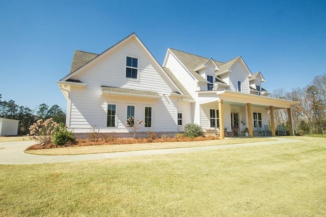 view of front of home with a front yard and roof with shingles