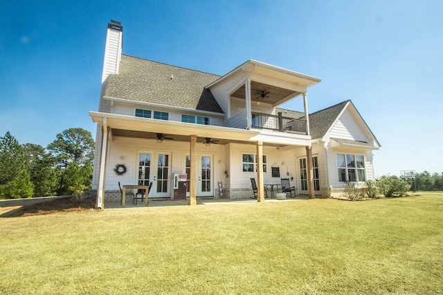 back of house featuring a balcony, a yard, ceiling fan, french doors, and a patio area