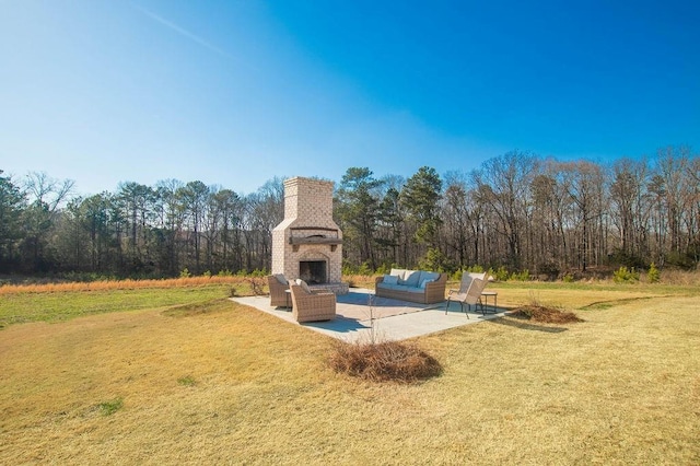 view of yard with a patio area and an outdoor living space with a fireplace