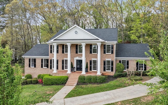 6124 Kings Mountain Ct, Stone Mountain, GA 30087 - neoclassical home featuring brick siding, a front yard, and roof with shingles