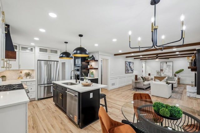 6124 Kings Mountain Ct, Stone Mountain, GA 30087 - kitchen with light countertops, a sink, light wood-style floors, a decorative wall, and appliances with stainless steel finishes