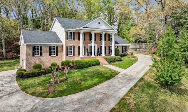 6124 Kings Mountain Ct, Stone Mountain, GA 30087 - neoclassical home featuring fence, a garage, a front lawn, driveway, and a porch
