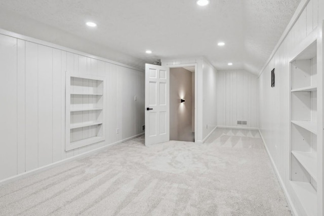 6124 Kings Mountain Ct, Stone Mountain, GA 30087 - finished basement featuring a textured ceiling, visible vents, baseboards, built in shelves, and carpet floors