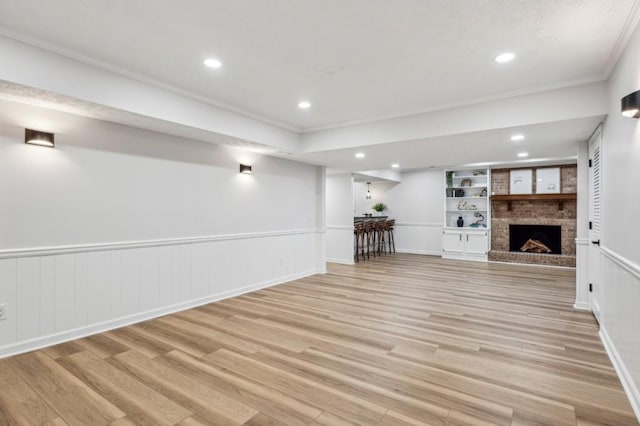 6124 Kings Mountain Ct, Stone Mountain, GA 30087 - unfurnished living room with light wood-style flooring, a wainscoted wall, a brick fireplace, and recessed lighting