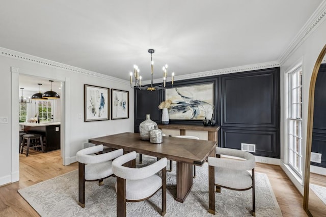 6124 Kings Mountain Ct, Stone Mountain, GA 30087 - dining area featuring visible vents, crown molding, light wood-style floors, a wealth of natural light, and an inviting chandelier