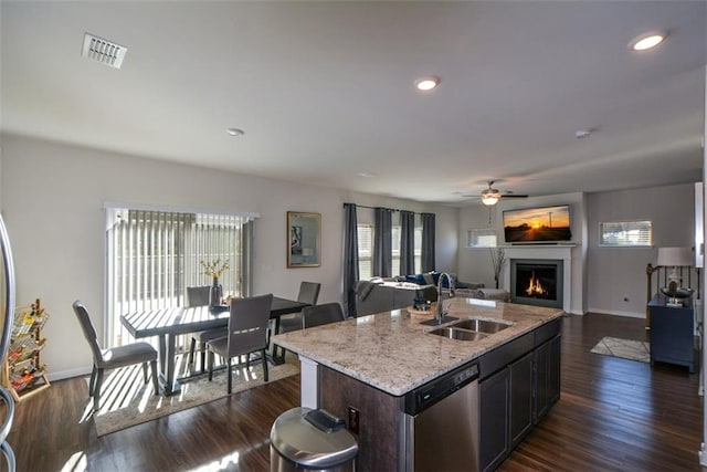 kitchen with a kitchen island with sink, sink, stainless steel dishwasher, and a healthy amount of sunlight