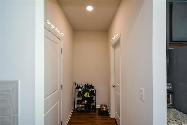 corridor with dark hardwood / wood-style flooring