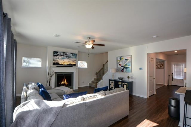 living room with dark hardwood / wood-style flooring and ceiling fan