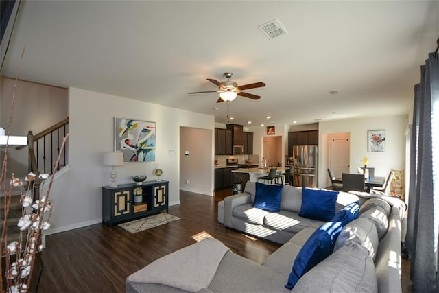 living room with dark hardwood / wood-style flooring and ceiling fan