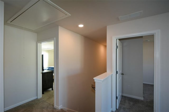 hall with dark colored carpet