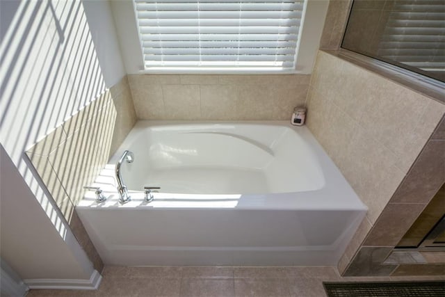 bathroom with tile patterned flooring and a tub