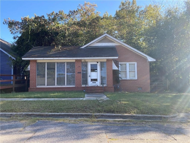 view of front of home featuring crawl space, a front yard, and brick siding