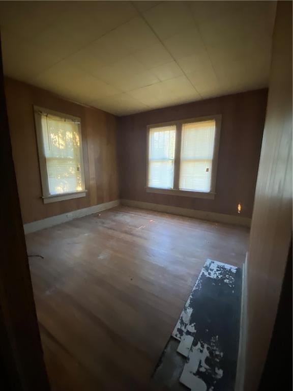 spare room featuring baseboards and wood finished floors