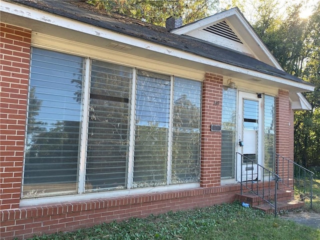 view of side of home with entry steps and brick siding