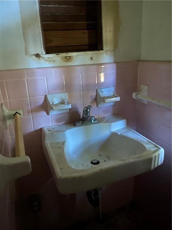 half bathroom featuring a sink and tile walls