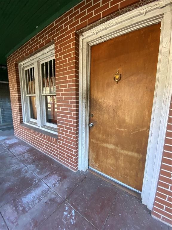 property entrance featuring brick siding