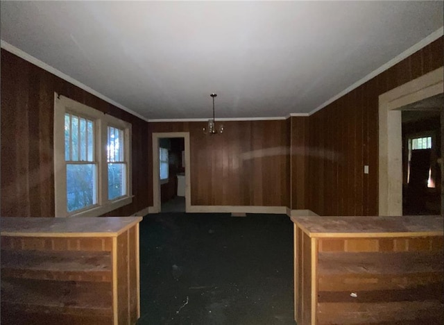 unfurnished dining area featuring wood walls and crown molding